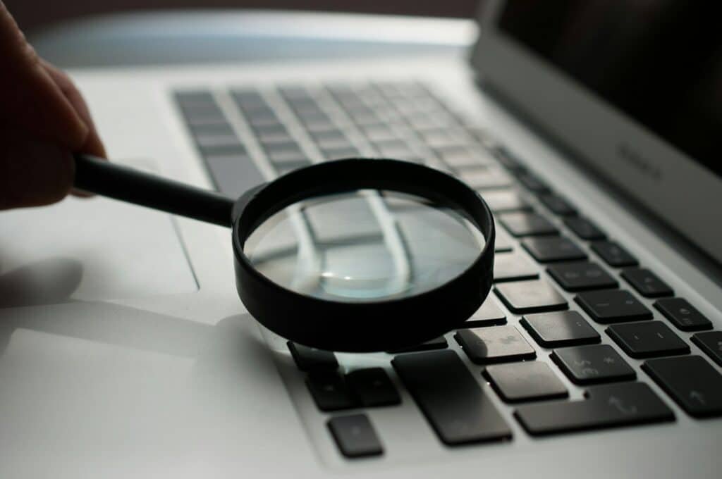 Loupe devant un ordinateur portable, symbole de l'audit de référencement